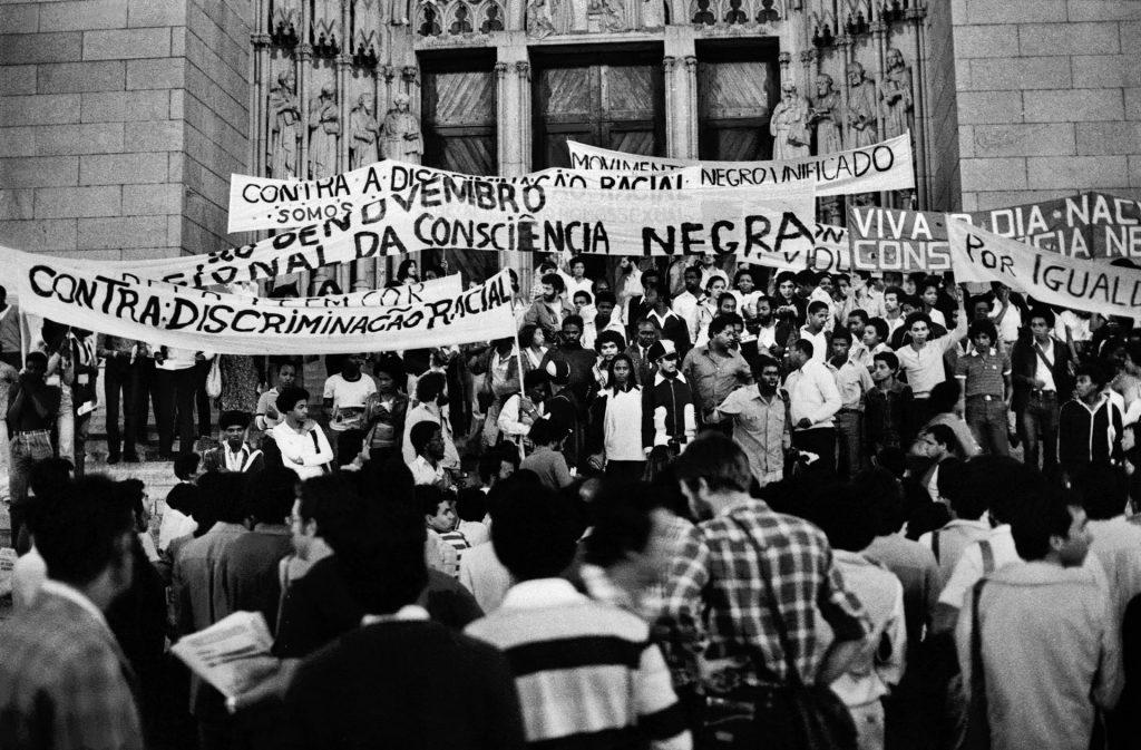 Manifestação do Movimento Negro Unificado (MNU), contra a lei Afonso Arinos (Lei nº 1.390, de 3 de julho de 1951), que foi a primeira legislação brasileira a classificar o racismo como contravenção penal, ou seja, como um delito de menor potencial ofensivo — e não como crime propriamente dito. São Paulo, 1980. Foto: Jesus Carlos. Direitos de reprodução reservados.